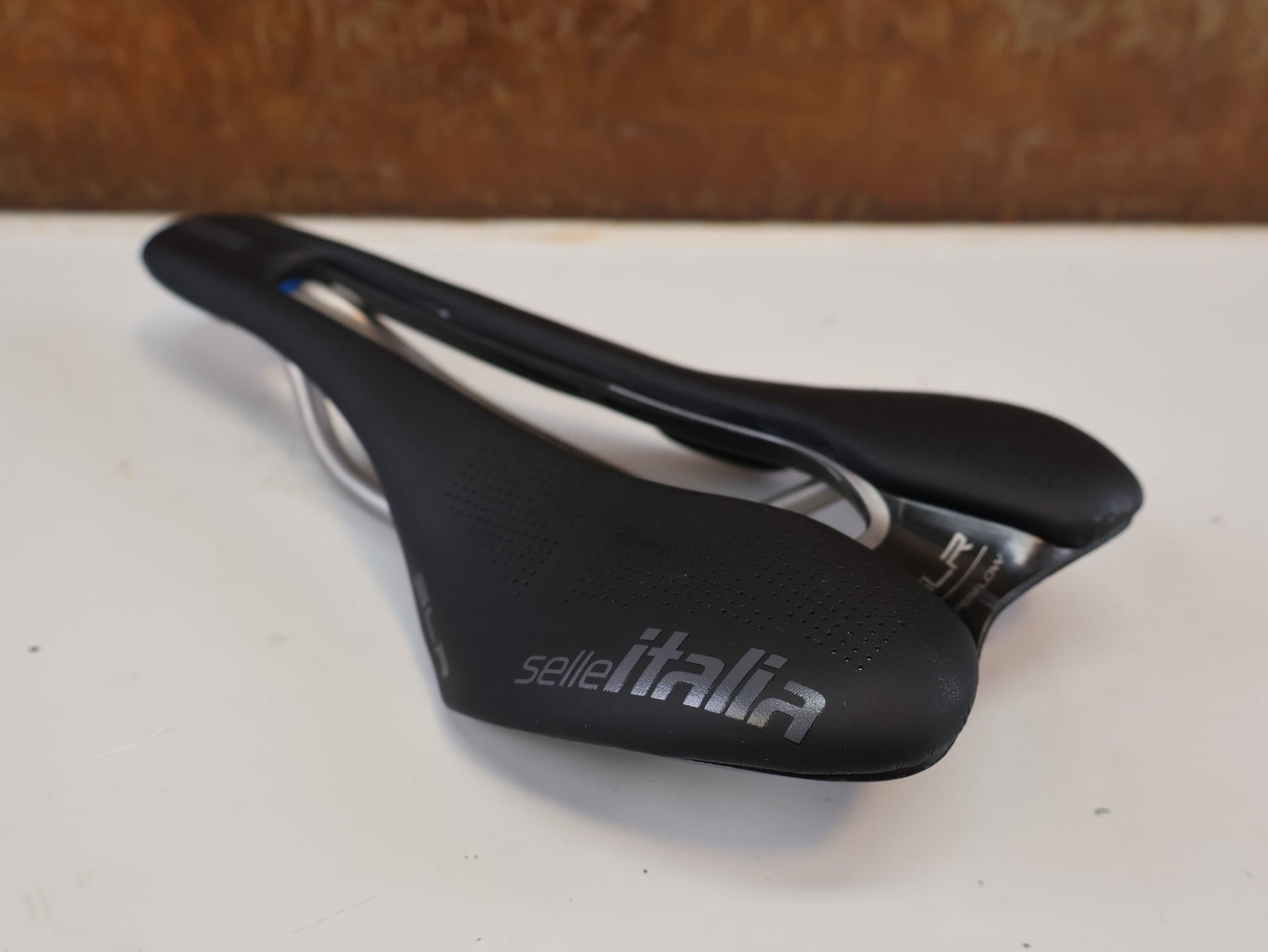Sattel von Prologo, SELLE ITALIA SLR BOOST TI SUPERFLOW / RENNRAD SATTEL / S3 130 MM / TITAN vor USEDBIKES-OB.DE Hintergrund