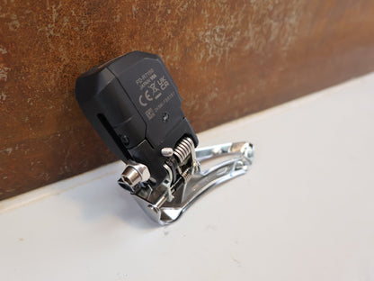 Schaltungsteile von Shimano, SHIMANO 105 DI2 UMWERFER FD-R7150 / 2X12-FACH / ANLÖT / 142 G vor USEDBIKES-OB.DE Hintergrund
