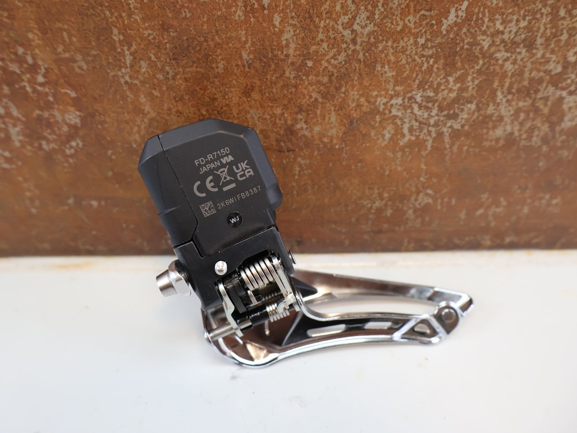 Schaltungsteile von Shimano, SHIMANO 105 DI2 UMWERFER FD-R7150 / 2X12-FACH / ANLÖT / 142 G vor USEDBIKES-OB.DE Hintergrund