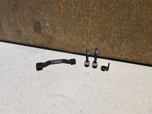 Zubehör von Shimano, SHIMANO ADAPTER POSTMOUNT 203MM / VORNE O. HINTEN vor USEDBIKES - OB.DE Hintergrund