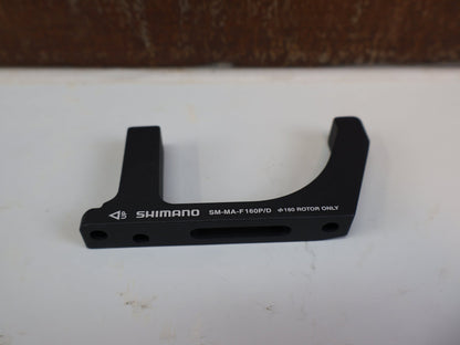 Bremsadapter von Shimano, SHIMANO ADAPTER SM-MA-F160P/D / FLATMOUNT GABEL AUF PM SATTEL / VR 160 MM vor USEDBIKES-OB.DE Hintergrund
