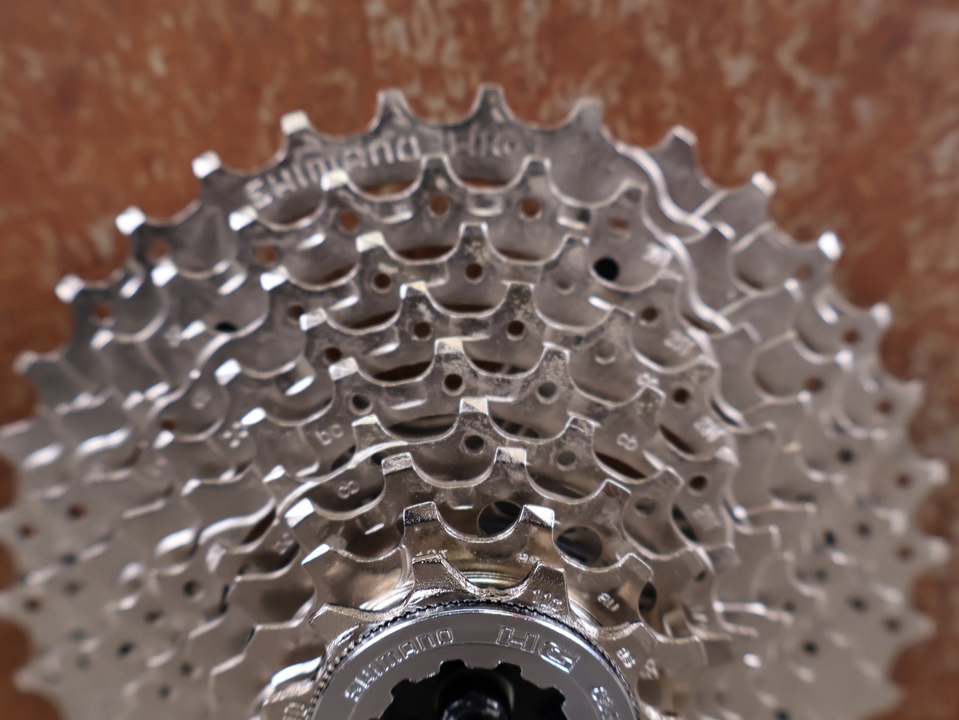 Kassette & Zahnkränze von Shimano, SHIMANO ALIVIO CS - HG400 - 9 KASSETTE / 9 - FACH / 11 - 34 ZÄHNE / HYPERGLIDE / SILVER vor USEDBIKES - OB.DE Hintergrund