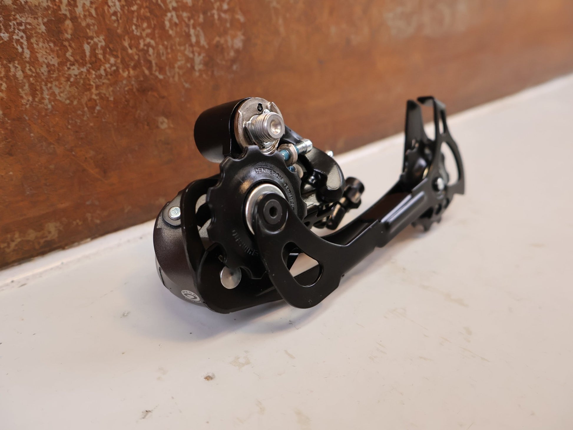 Schaltungsteile von Shimano, SHIMANO ALTUS RD M370 SCHALTWERK 9 FACH MAX 34 T vor USEDBIKES-OB.DE Hintergrund