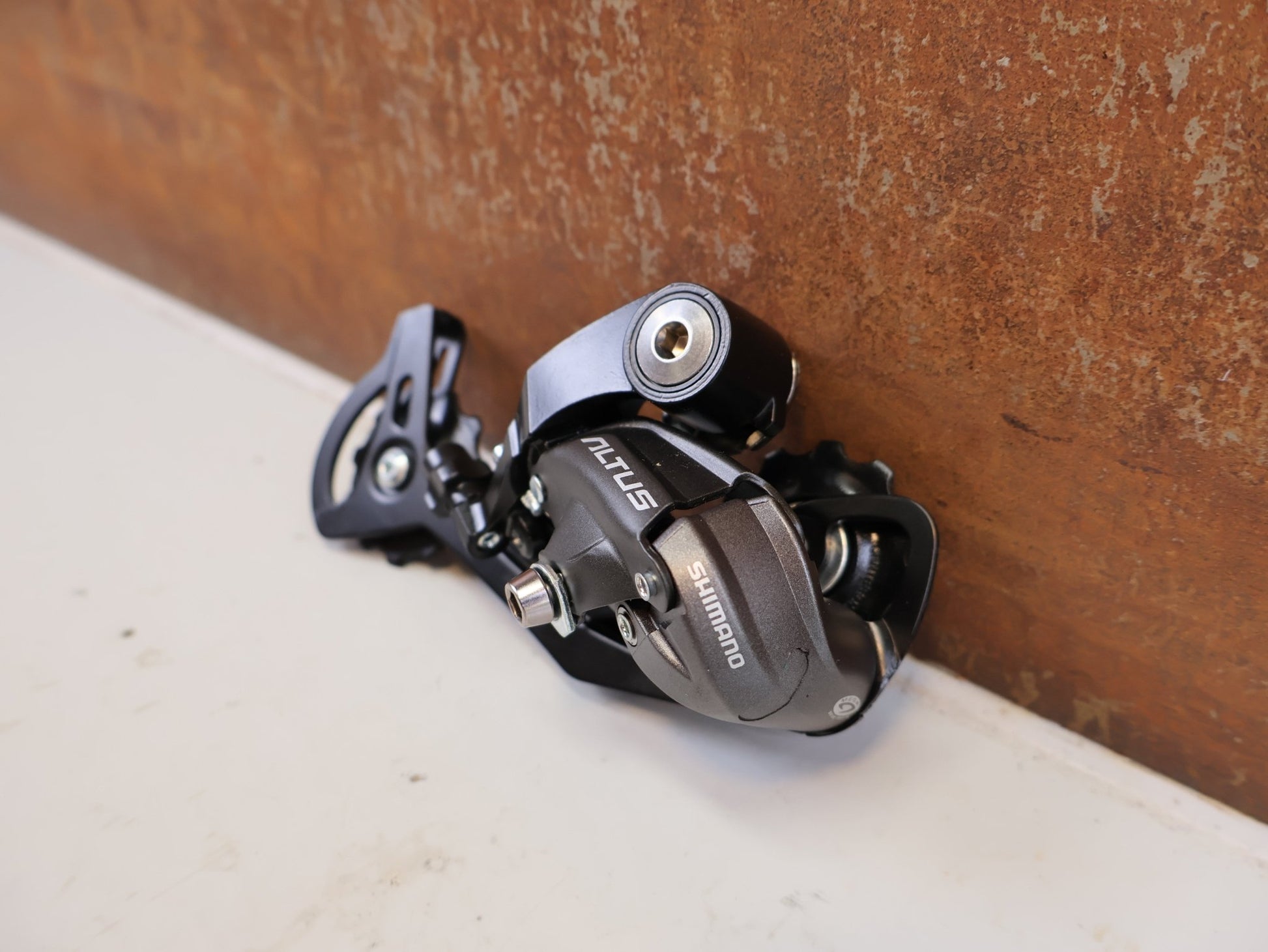 Schaltungsteile von Shimano, SHIMANO ALTUS RD M370 SCHALTWERK 9 FACH MAX 34 T vor USEDBIKES-OB.DE Hintergrund