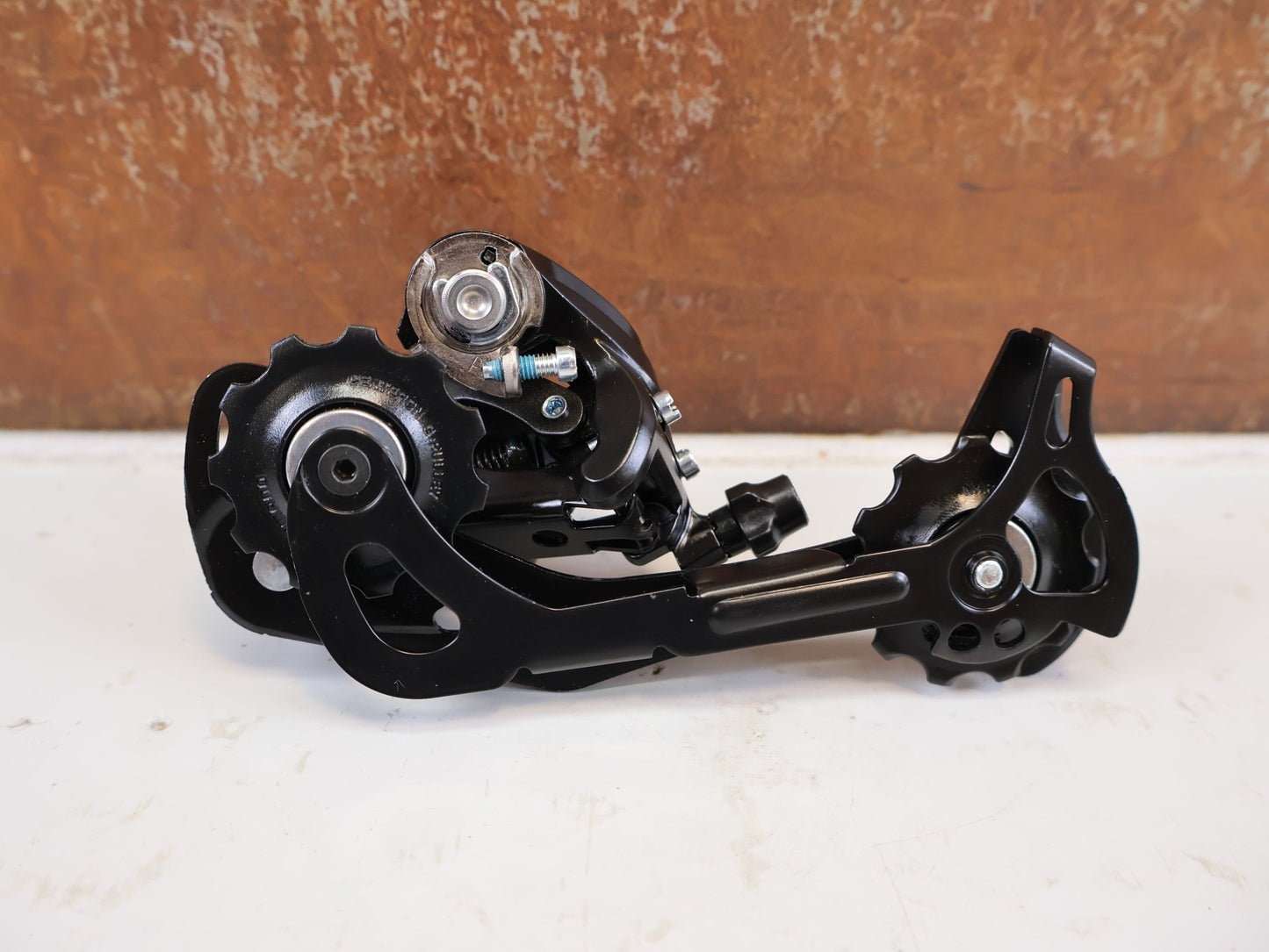 Schaltungsteile von Shimano, SHIMANO ALTUS RD M370 SCHALTWERK 9 FACH MAX 34 T vor USEDBIKES-OB.DE Hintergrund