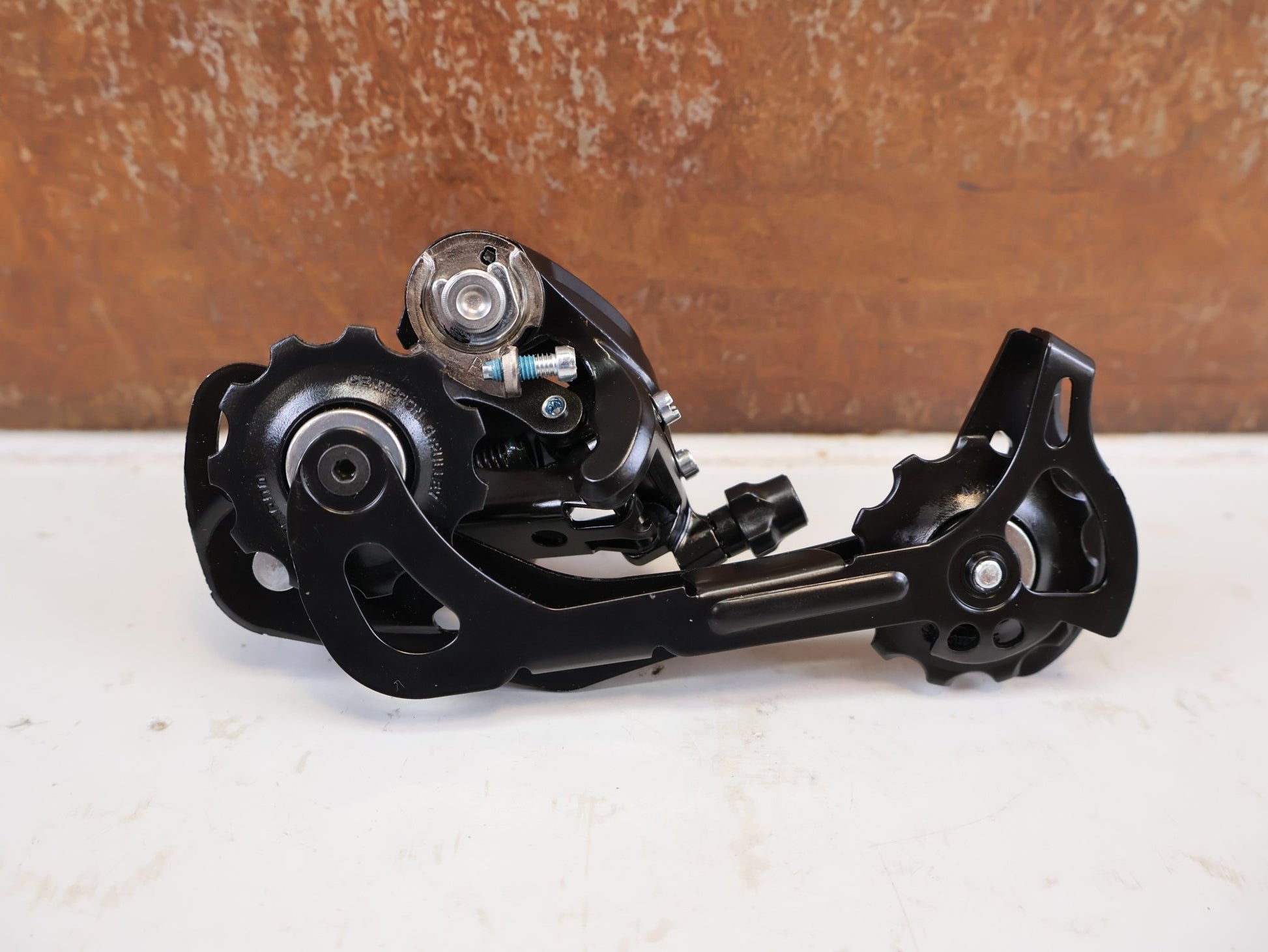 Schaltungsteile von Shimano, SHIMANO ALTUS RD M370 SCHALTWERK 9 FACH MAX 34 T vor USEDBIKES-OB.DE Hintergrund