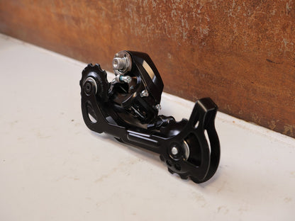 Schaltungsteile von Shimano, SHIMANO ALTUS RD M370 SCHALTWERK 9 FACH MAX 34 T vor USEDBIKES-OB.DE Hintergrund