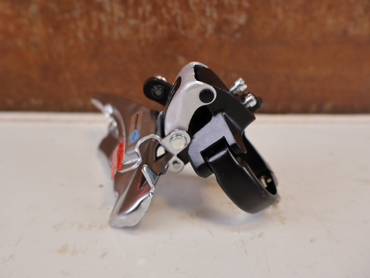 Schaltungsteile von Shimano, SHIMANO ALTUS UMWERFER FD-M313-6 3X7/8-FACH SCHELLE DUAL PULL vor USEDBIKES-OB.DE Hintergrund