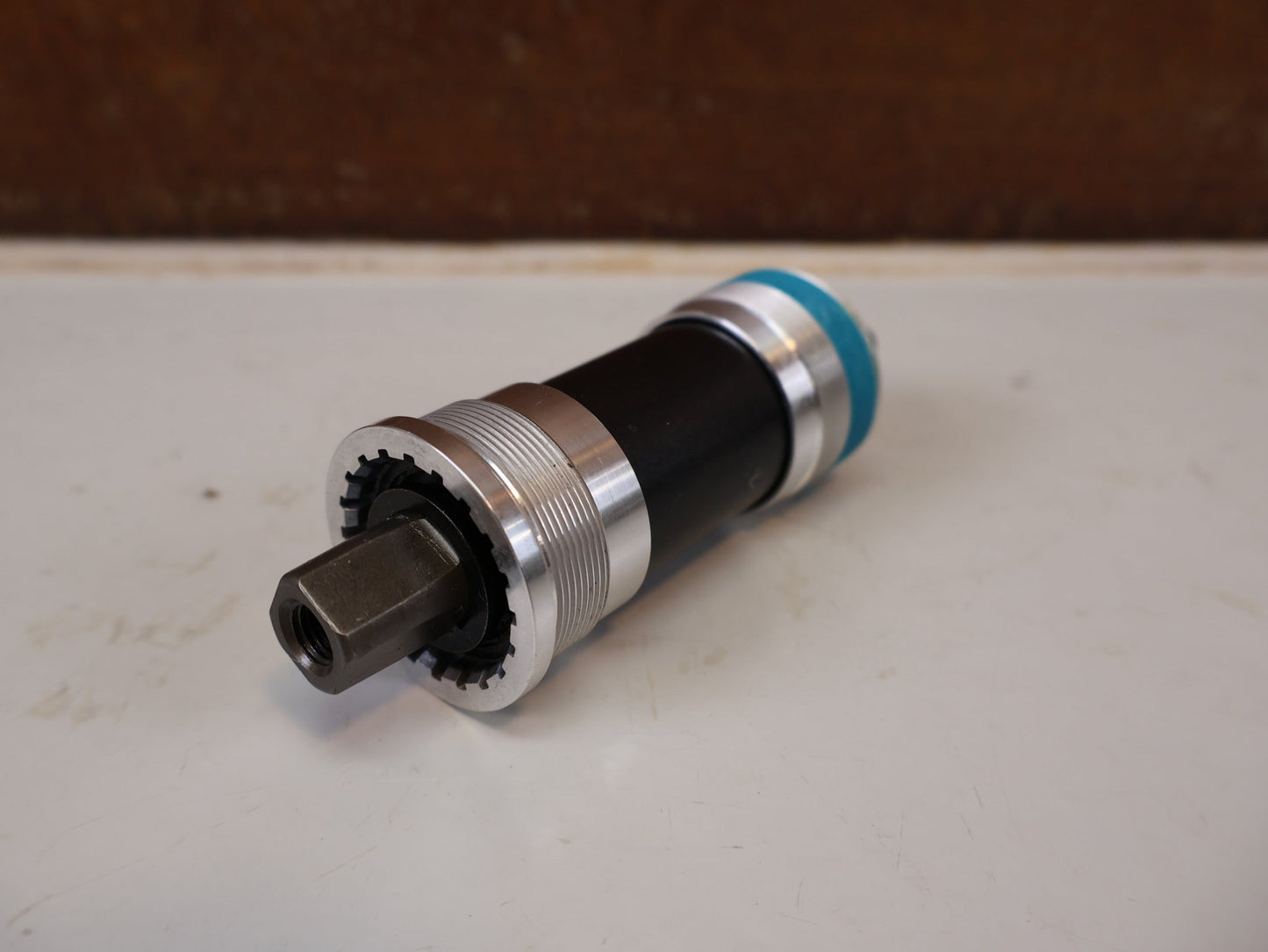 Innenlager von Shimano, SHIMANO BB-UN300-K INNENLAGER BSA 68MM / JIS 4-KANT KETTENKASTEN vor USEDBIKES-OB.DE Hintergrund