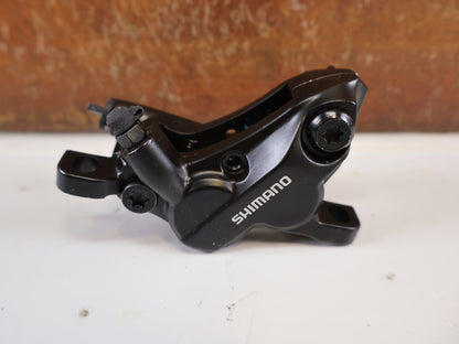 Bremse von Shimano, SHIMANO BR - MT520 BREMSSATTEL / 4 - KOLBEN / POSTMOUNT / KERAMIK - KOLBEN / EBRMT520MPRXL vor USEDBIKES - OB.DE Hintergrund