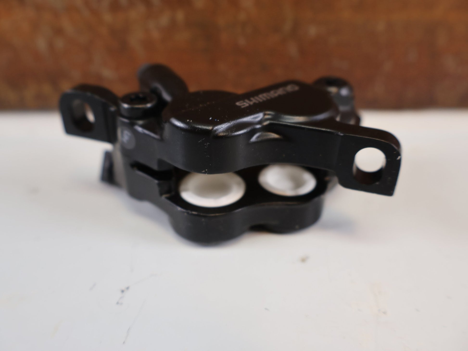Bremse von Shimano, SHIMANO BR - MT520 BREMSSATTEL / 4 - KOLBEN / POSTMOUNT / KERAMIK - KOLBEN / EBRMT520MPRXL vor USEDBIKES - OB.DE Hintergrund