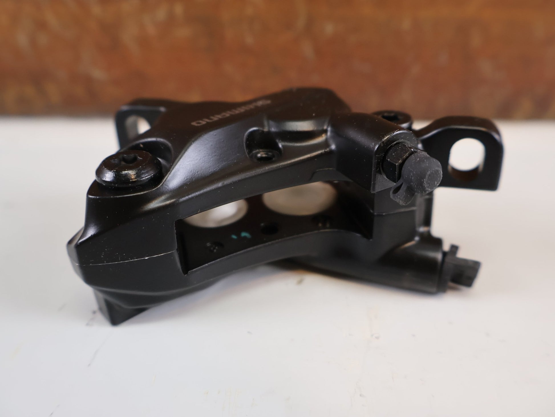 Bremse von Shimano, SHIMANO BR - MT520 BREMSSATTEL / 4 - KOLBEN / POSTMOUNT / KERAMIK - KOLBEN / EBRMT520MPRXL vor USEDBIKES - OB.DE Hintergrund