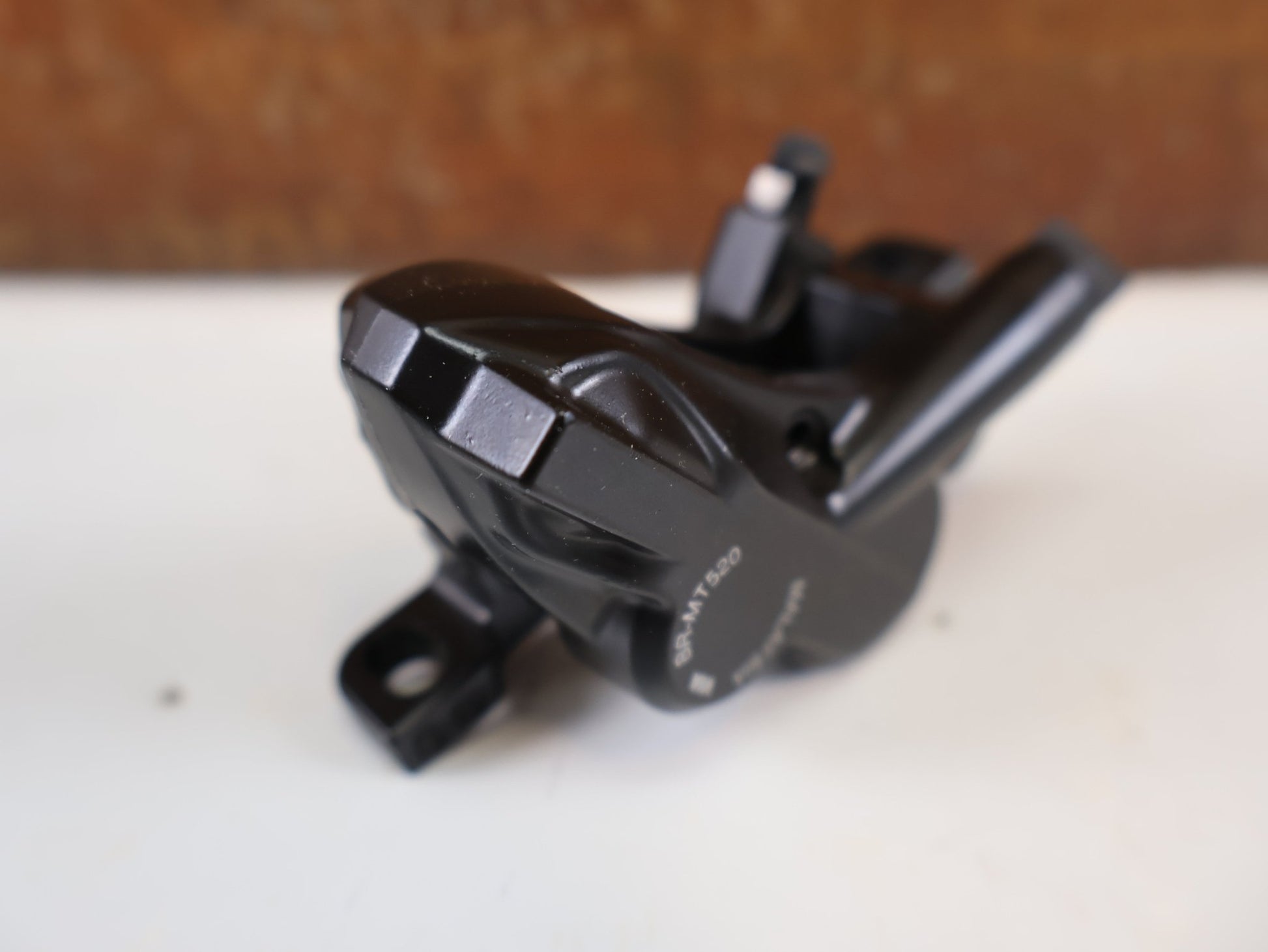 Bremse von Shimano, SHIMANO BR - MT520 BREMSSATTEL / 4 - KOLBEN / POSTMOUNT / KERAMIK - KOLBEN / EBRMT520MPRXL vor USEDBIKES - OB.DE Hintergrund