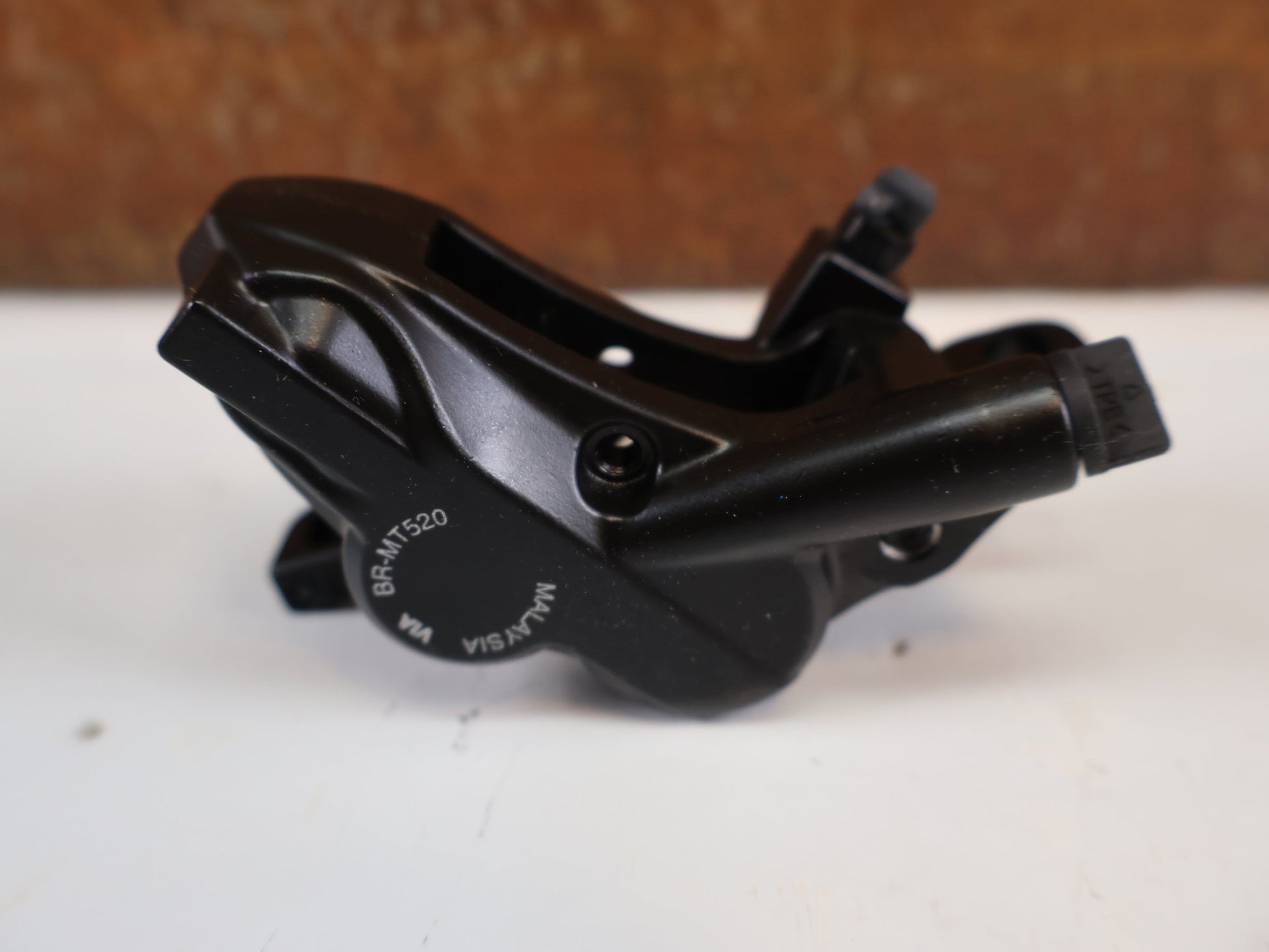 Bremse von Shimano, SHIMANO BR - MT520 BREMSSATTEL / 4 - KOLBEN / POSTMOUNT / KERAMIK - KOLBEN / EBRMT520MPRXL vor USEDBIKES - OB.DE Hintergrund