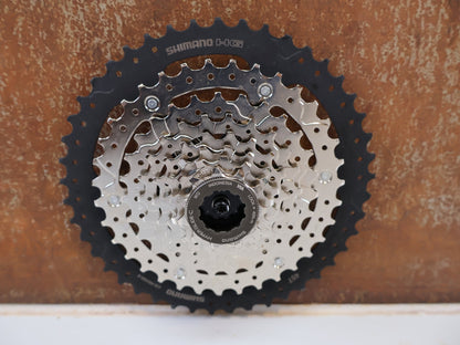 Kassette & Zahnkränze von Shimano, SHIMANO CS-HG400-8 KASSETTE / 8-FACH 11-40 ZÄHNE MEGA RANGE HYPERGLIDE MTB vor USEDBIKES-OB.DE Hintergrund