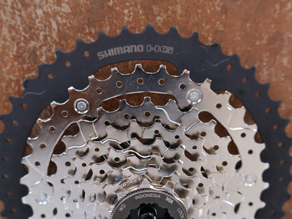 Kassette & Zahnkränze von Shimano, SHIMANO CS-HG400-8 KASSETTE / 8-FACH 11-40 ZÄHNE MEGA RANGE HYPERGLIDE MTB vor USEDBIKES-OB.DE Hintergrund