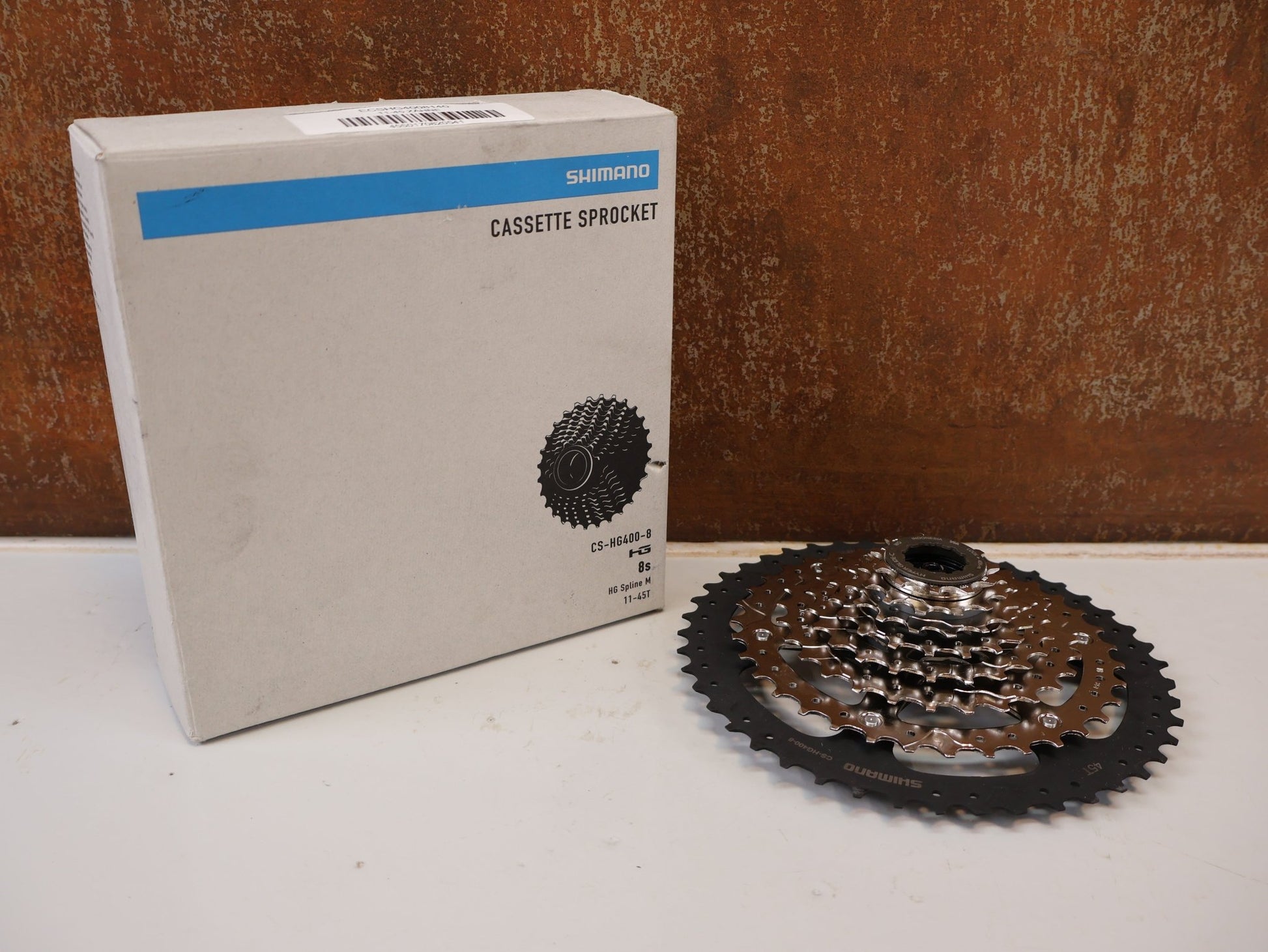 Kassette & Zahnkränze von Shimano, SHIMANO CS-HG400-8 KASSETTE / 8-FACH 11-40 ZÄHNE MEGA RANGE HYPERGLIDE MTB vor USEDBIKES-OB.DE Hintergrund