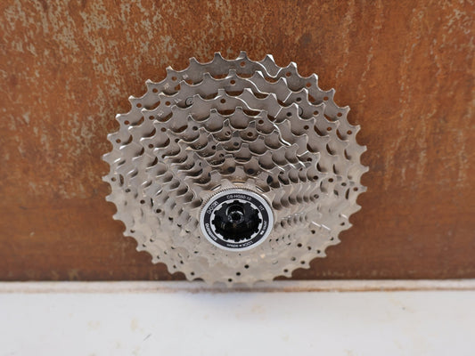 Kassette & Zahnkränze von Shimano, SHIMANO CS-HG50 10-FACH KASSETTE 11-36 SILBER CS-HG50-10 MTB TREKKING vor USEDBIKES-OB.DE Hintergrund