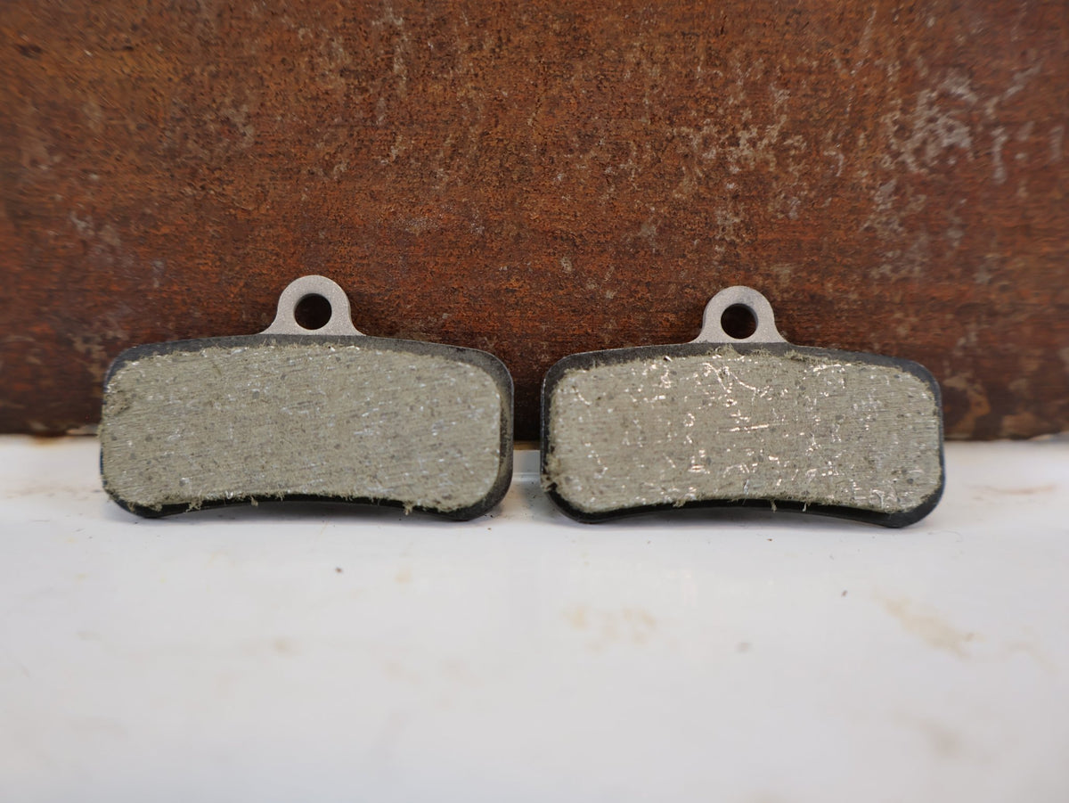Bremsbelag von Shimano, Shimano D03S Resin Bremsbeläge 4-Kolben XT SLX EBP D03SRXA vor USEDBIKES-OB.DE Hintergrund