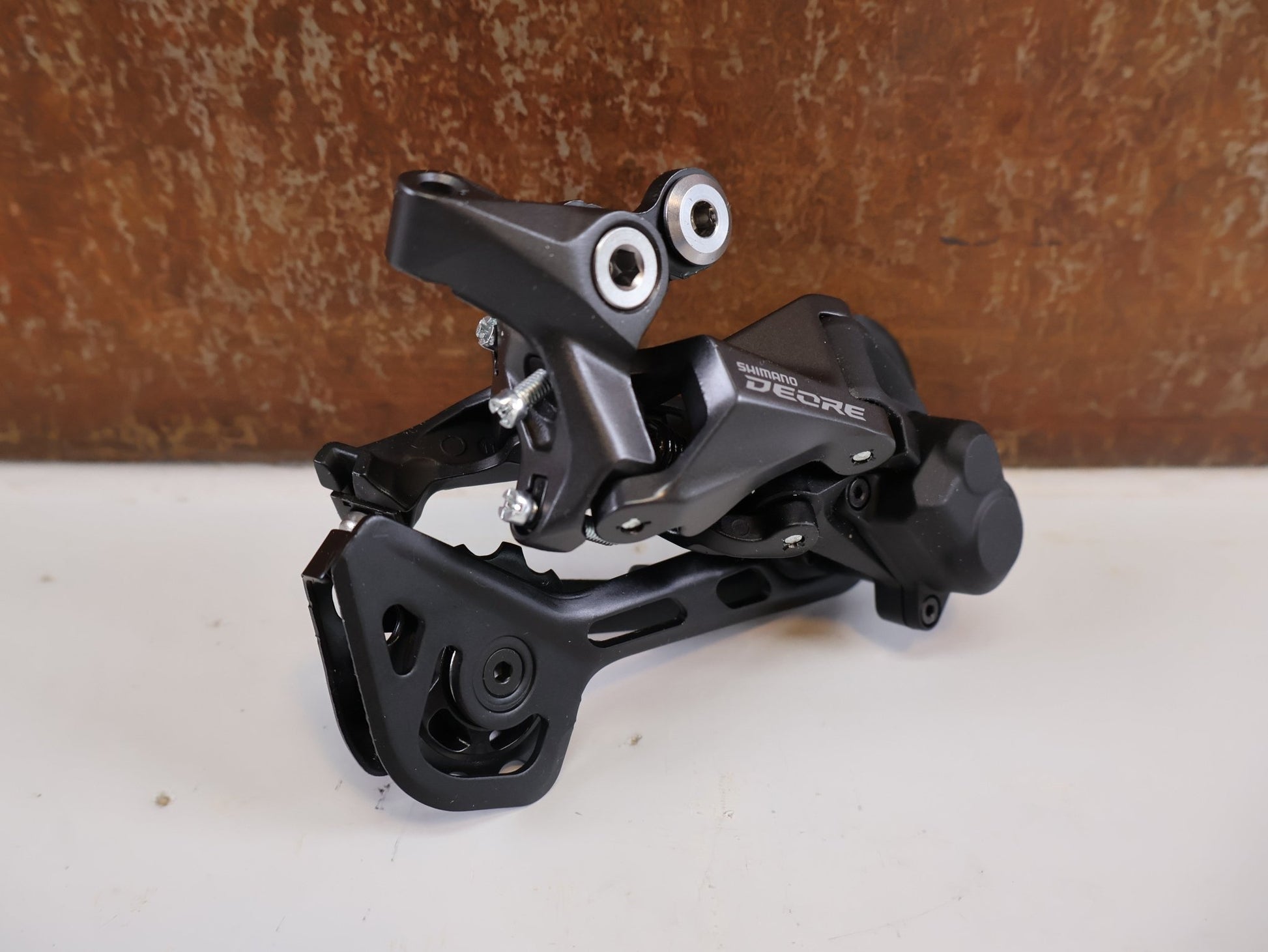 Schaltungsteile von Shimano, SHIMANO DEORE RD - M5120 SCHALTWERK / 10/11 - FACH / SHADOW RD+ / SGS LANG / 4550170618544 vor USEDBIKES - OB.DE Hintergrund
