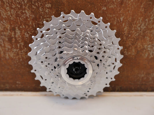 Kassette & Zahnkränze von Shimano, SHIMANO DEORE XT CS-M771-10 KASSETTE / 10-FACH 11-32Z HG RITZELPAKET vor USEDBIKES-OB.DE Hintergrund