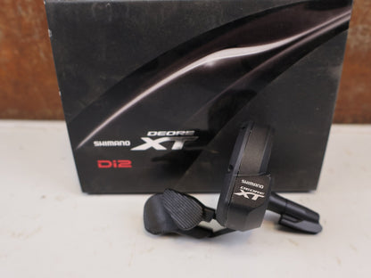 Schaltungsteile von Shimano, SHIMANO DEORE XT DI2 SW M8050 SCHALTHEBEL LINKS vor USEDBIKES-OB.DE Hintergrund