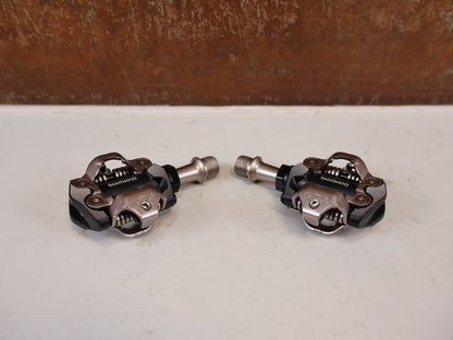 Pedale von Shimano, Shimano Deore XT PD-M8100 SPD Pedale Klickpedale 342g vor USEDBIKES-OB.DE Hintergrund