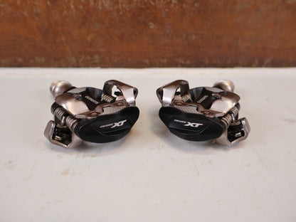 Pedale von Shimano, Shimano Deore XT PD-M8100 SPD Pedale Klickpedale 342g vor USEDBIKES-OB.DE Hintergrund