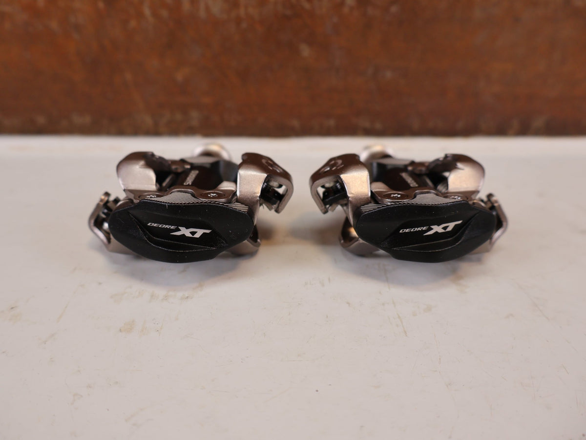 Pedale von Shimano, Shimano Deore XT PD-M8100 SPD Pedale Klickpedale 342g vor USEDBIKES-OB.DE Hintergrund