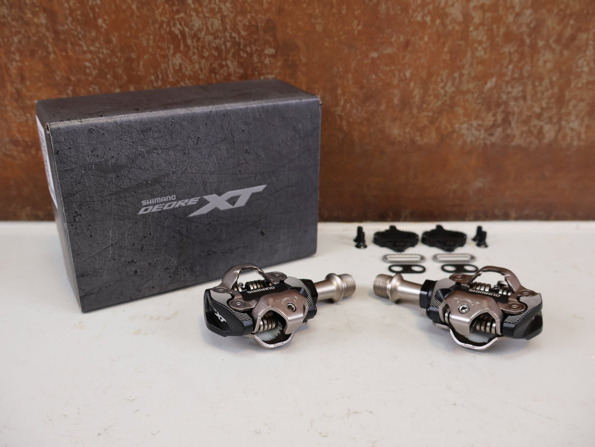 Pedale von Shimano, Shimano Deore XT PD-M8100 SPD Pedale Klickpedale 342g vor USEDBIKES-OB.DE Hintergrund