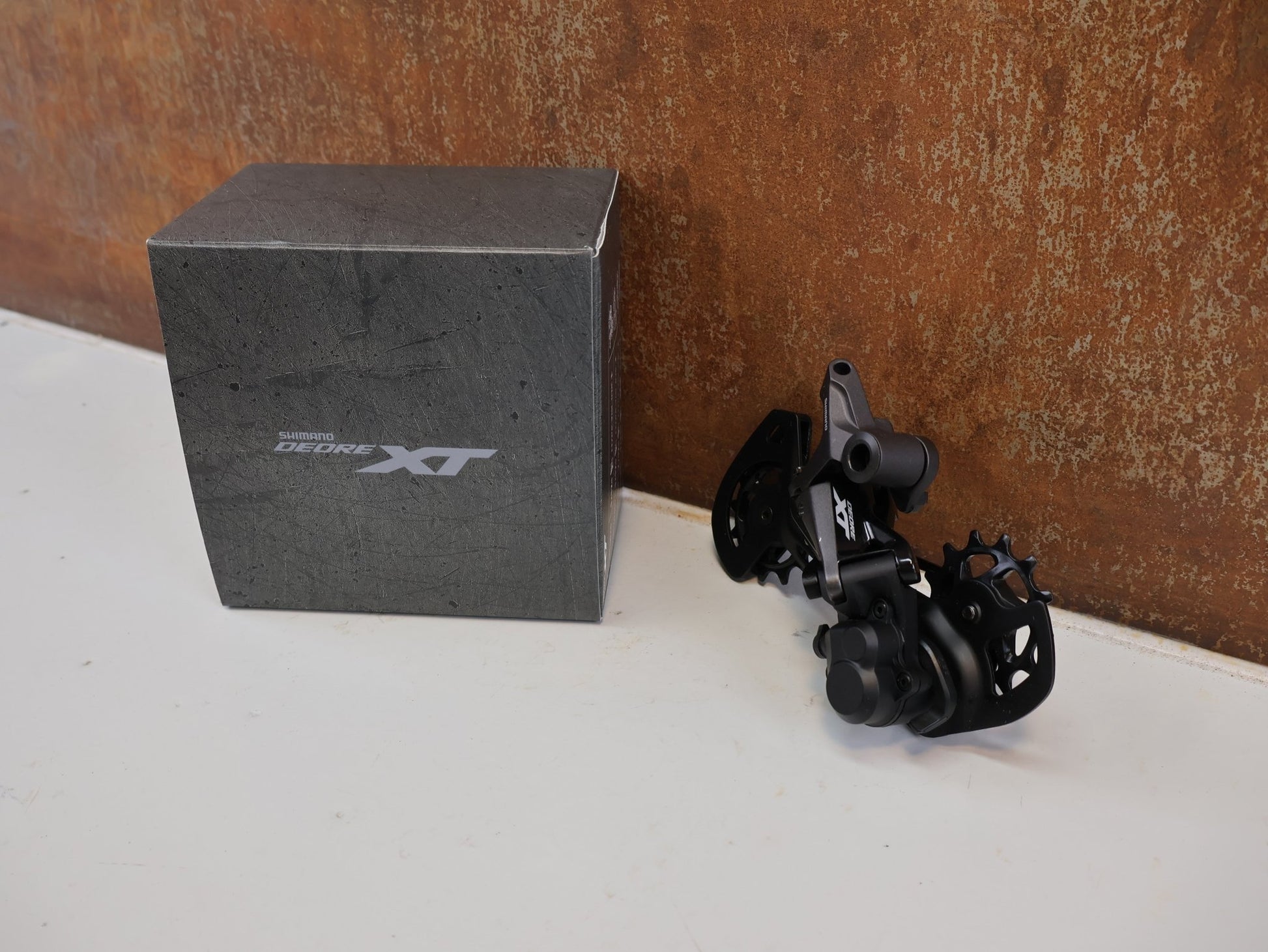 Schaltungsteile von Shimano, SHIMANO DEORE XT RD-M8120 / SCHALTWERK / 2X12-FACH / LONG CAGE vor USEDBIKES-OB.DE Hintergrund
