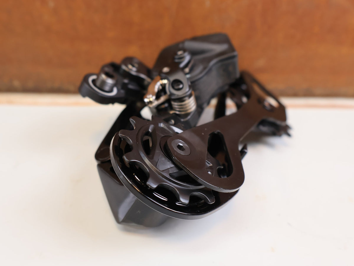 Schaltungsteile von Shimano, Shimano Dura-Ace Di2 RD-R9250 12-fach Schaltwerk Carbon vor USEDBIKES-OB.DE Hintergrund