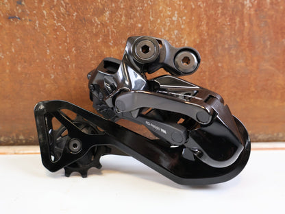 Schaltungsteile von Shimano, Shimano Dura-Ace Di2 RD-R9250 12-fach Schaltwerk Carbon vor USEDBIKES-OB.DE Hintergrund