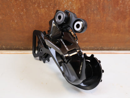 Schaltungsteile von Shimano, Shimano Dura-Ace Di2 RD-R9250 12-fach Schaltwerk Carbon vor USEDBIKES-OB.DE Hintergrund