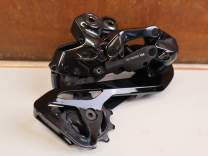 Schaltungsteile von Shimano, Shimano Dura-Ace Di2 RD-R9250 12-fach Schaltwerk Carbon vor USEDBIKES-OB.DE Hintergrund