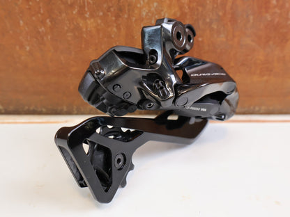 Schaltungsteile von Shimano, Shimano Dura-Ace Di2 RD-R9250 12-fach Schaltwerk Carbon vor USEDBIKES-OB.DE Hintergrund