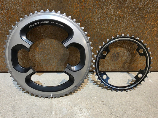 Kettenblatt von Shimano, SHIMANO DURA ACE FC - 9000 KETTENBLATT SET 52 / 36 ZÄHNE in variant_title vor USEDBIKES - OB.DE Hintergrund