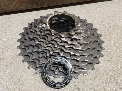 Kassette & Zahnkränze von Shimano, SHIMANO DURA ACE KASSETTE CS - R9100 11 - 30 ZAHNKRANZ vor USEDBIKES - OB.DE Hintergrund