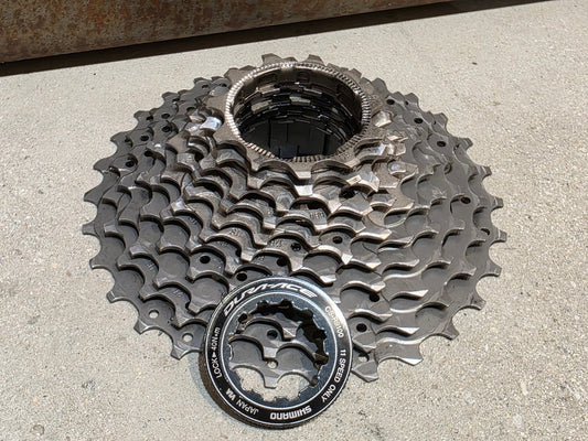 Kassette & Zahnkränze von Shimano, SHIMANO DURA ACE KASSETTE CS - R9100 11 - 30 ZAHNKRANZ vor USEDBIKES - OB.DE Hintergrund