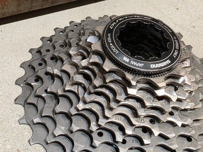 Kassette & Zahnkränze von Shimano, SHIMANO DURA ACE KASSETTE CS - R9100 11 - 30 ZAHNKRANZ vor USEDBIKES - OB.DE Hintergrund