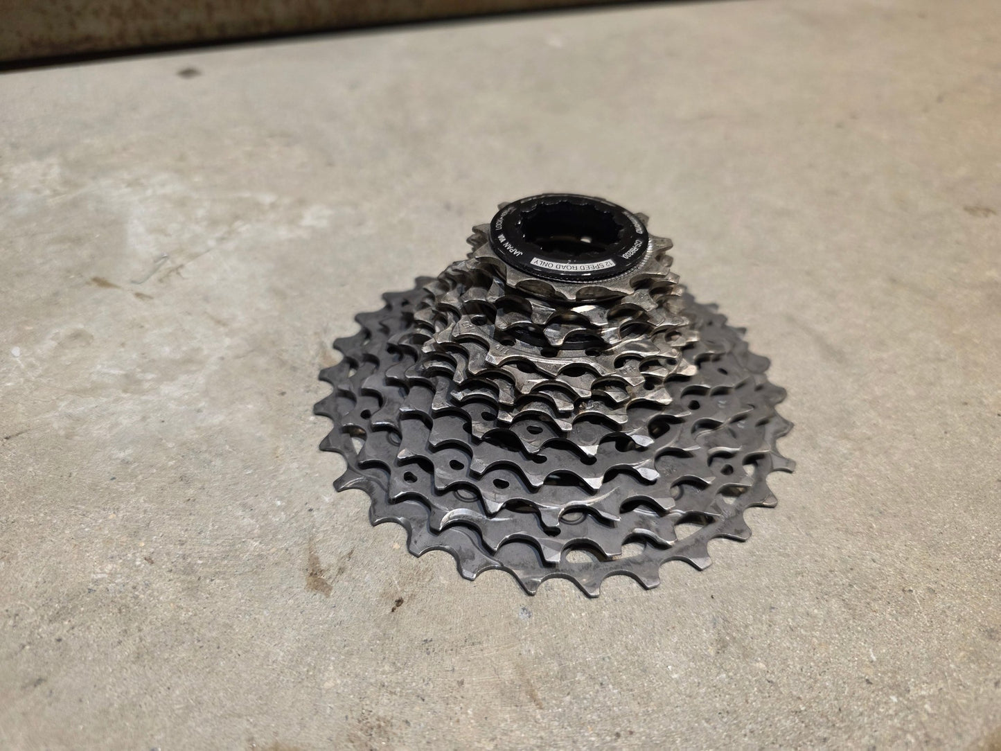 Kassette & Zahnkränze von Shimano, SHIMANO DURA ACE KASSETTE CS - R9200 12 FACH 11 - 30 ZÄHNE vor USEDBIKES - OB.DE Hintergrund
