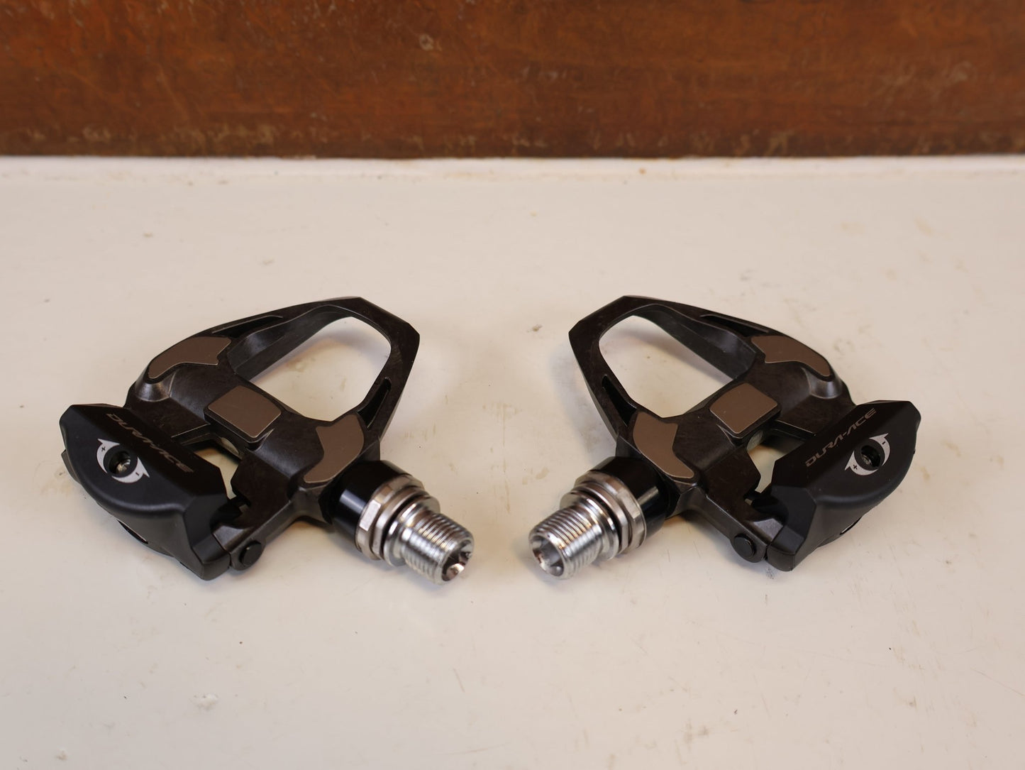 Pedale von Shimano, SHIMANO DURA ACE PD R9100 CARBON SPD SL PEDALE RENNRAD vor USEDBIKES-OB.DE Hintergrund