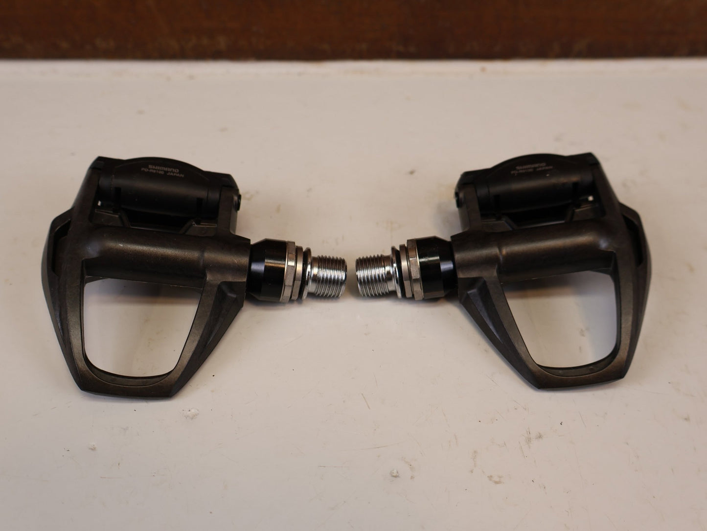 Pedale von Shimano, SHIMANO DURA ACE PD R9100 CARBON SPD SL PEDALE RENNRAD vor USEDBIKES-OB.DE Hintergrund