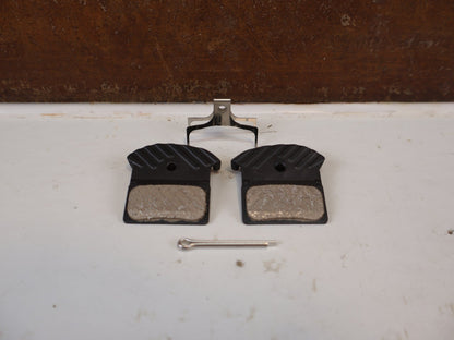 Bremsbelag von Shimano, Shimano J05A Resin Bremsbeläge XTR XT EBPJ05ARFA vor USEDBIKES-OB.DE Hintergrund