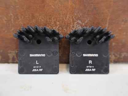 Bremsbelag von Shimano, Shimano J05A Resin Bremsbeläge XTR XT EBPJ05ARFA vor USEDBIKES-OB.DE Hintergrund