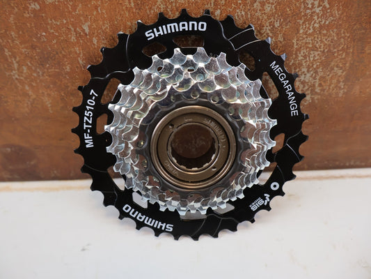 Kassette & Zahnkränze von Shimano, SHIMANO MF-TZ510-7 SCHRAUBKRANZ 7-FACH 14-34 ZÄHNE / EMFTZ5107434 vor USEDBIKES-OB.DE Hintergrund