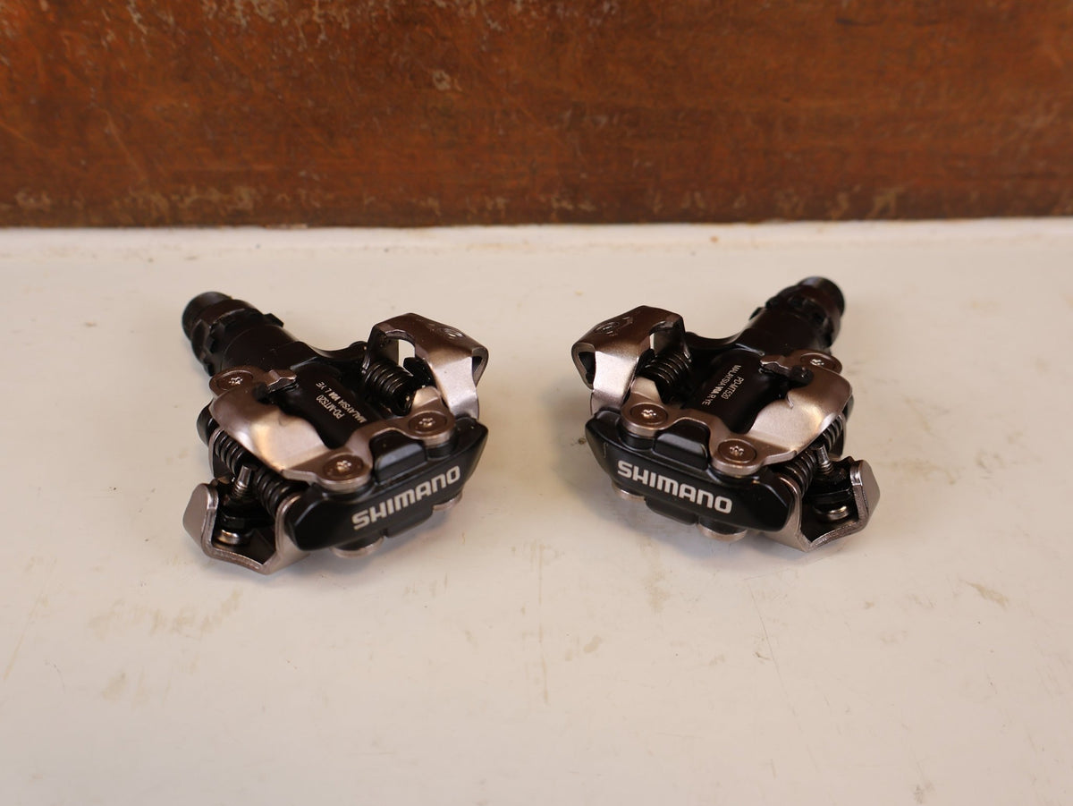 Pedale von Shimano, SHIMANO PD MT520 BEIDSEITIGE SPD KLICKPEDALE SCHWARZ vor USEDBIKES-OB.DE Hintergrund