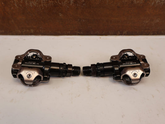 Pedale von Shimano, SHIMANO PD MT520 BEIDSEITIGE SPD KLICKPEDALE SCHWARZ vor USEDBIKES-OB.DE Hintergrund