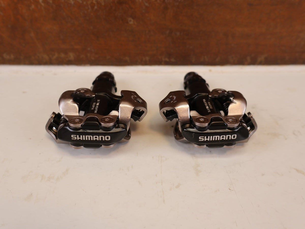 Pedale von Shimano, SHIMANO PD MT520 BEIDSEITIGE SPD KLICKPEDALE SCHWARZ vor USEDBIKES-OB.DE Hintergrund