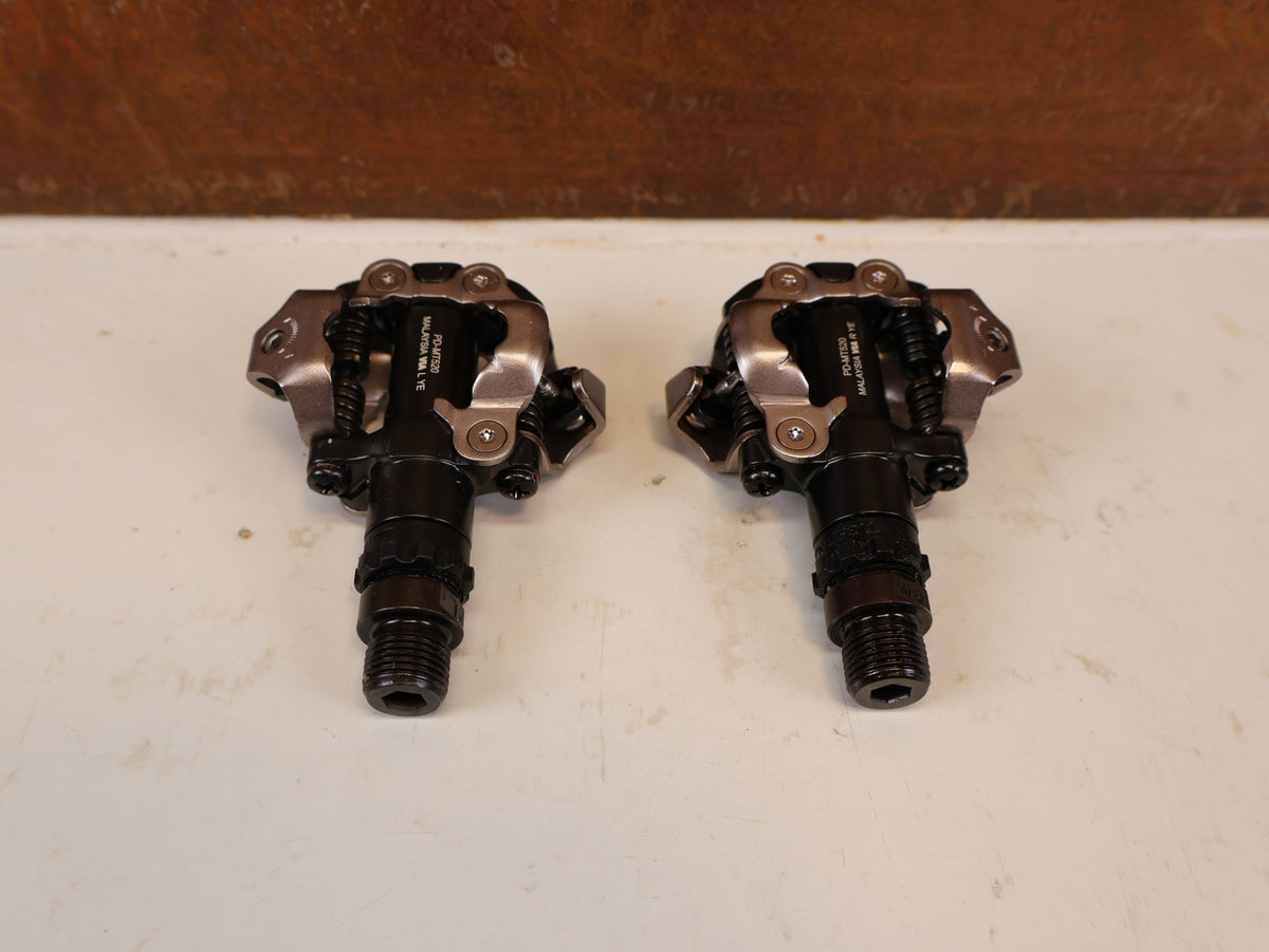 Pedale von Shimano, SHIMANO PD MT520 BEIDSEITIGE SPD KLICKPEDALE SCHWARZ vor USEDBIKES-OB.DE Hintergrund